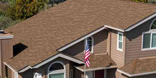 Exterior view of a home with tan siding and Trudefinition Duration COOL Shingles in Mojave color.