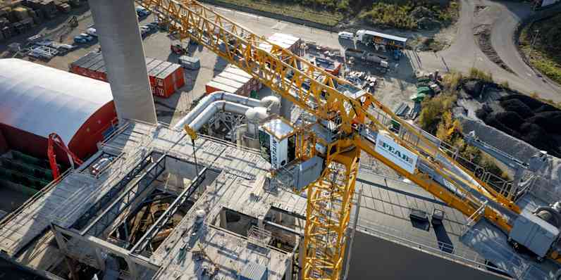 The construction site is seen from a drone perspective, with a large crane from Peab in the center.