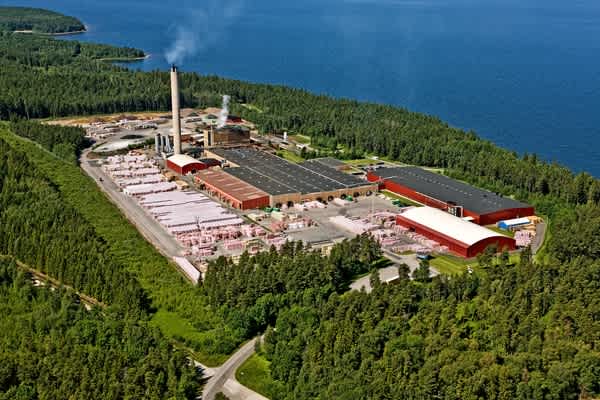 Paroc-fabrikken i Hällekis fra fugleperspektiv med vand og skov i baggrunden