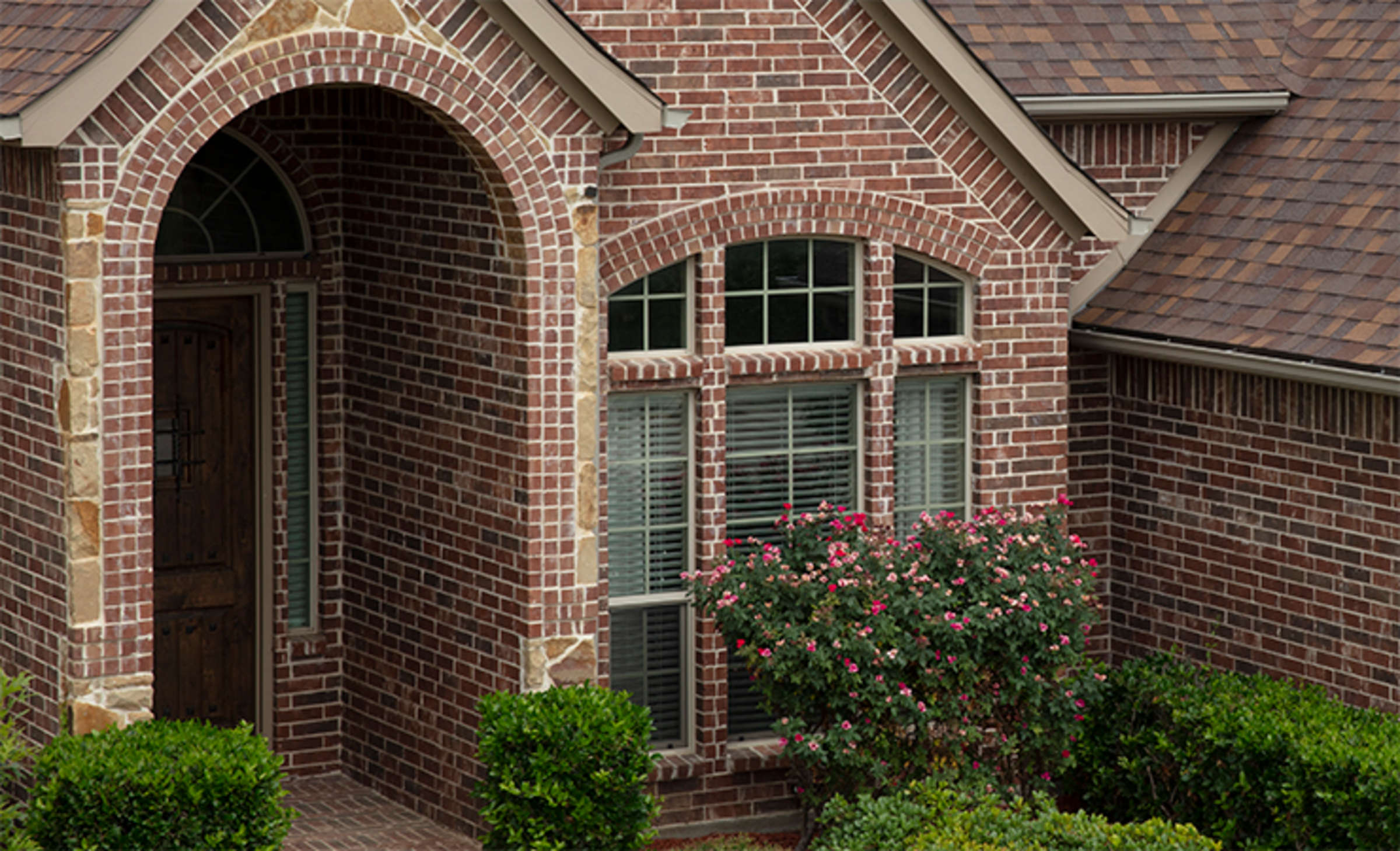 Red brick house with brown shingles