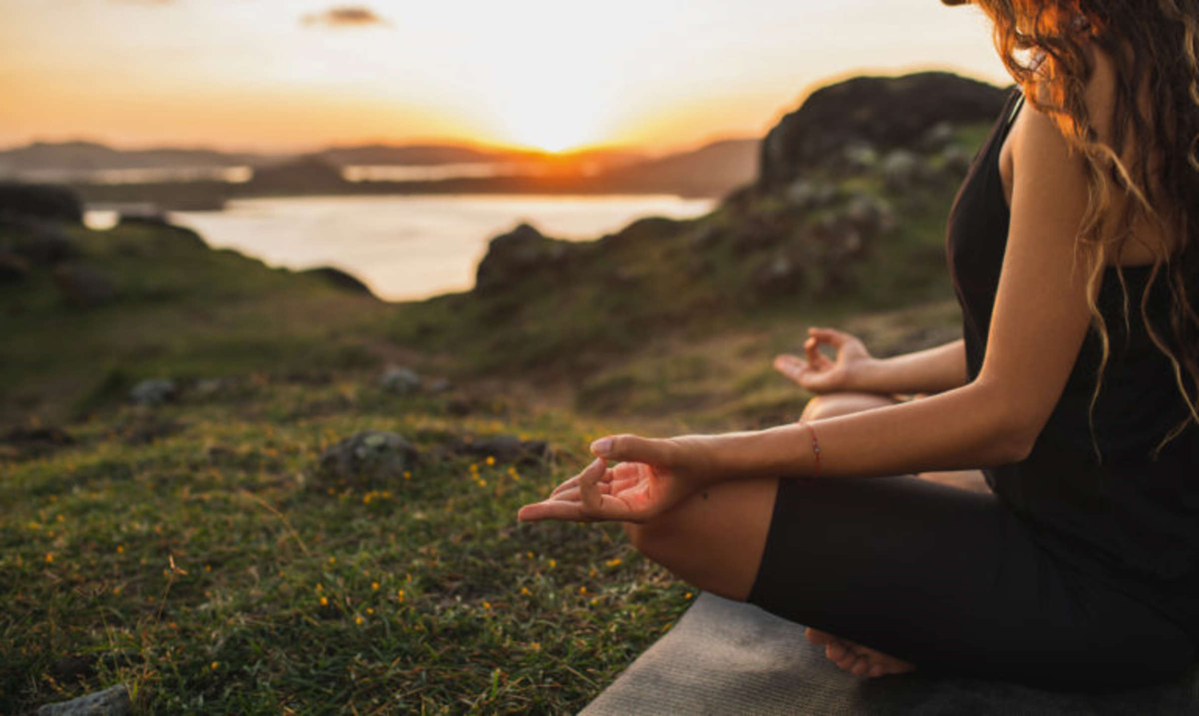 Woman meditating in the mountains at sunrise