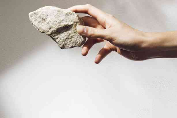 ranka, laikanti akmenį 