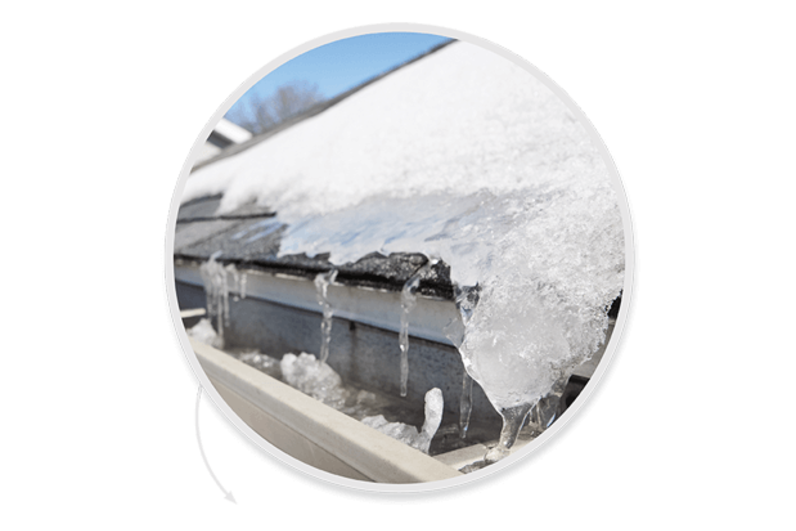 Closeup of roof with ice and snow encroaching into gutter