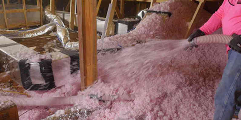 contractor installing insulation in buried ducts