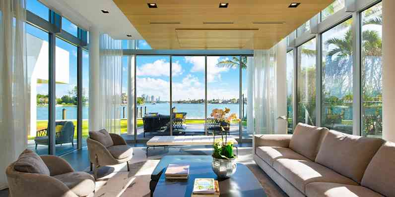 Light, airy enclosed porch with floor to ceiling glass doors, with a waterfront view