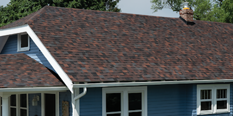 Blue home with white trim and Duration Designer shingles in Bourbon color.
