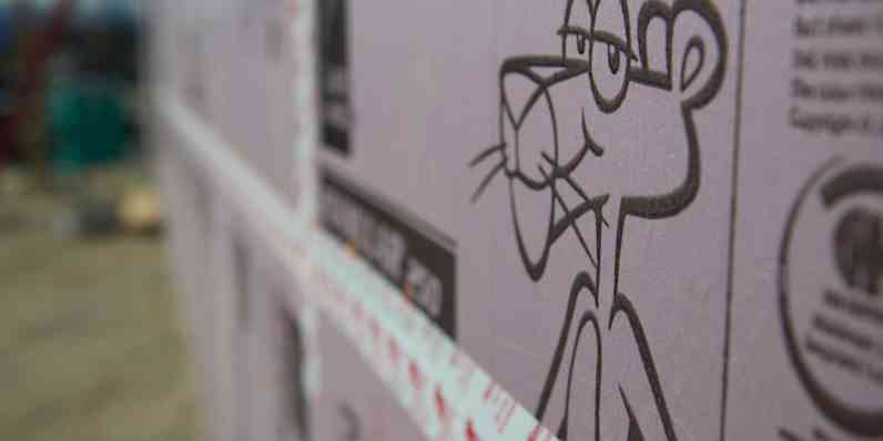 Foam board insulation stands against a wall with a focal point on the Pink Panther decal on the board.
