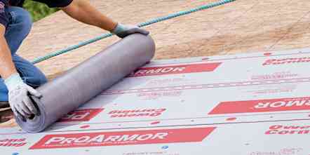 Photo of a contractor on top of a roof installing ProArmor underlayment