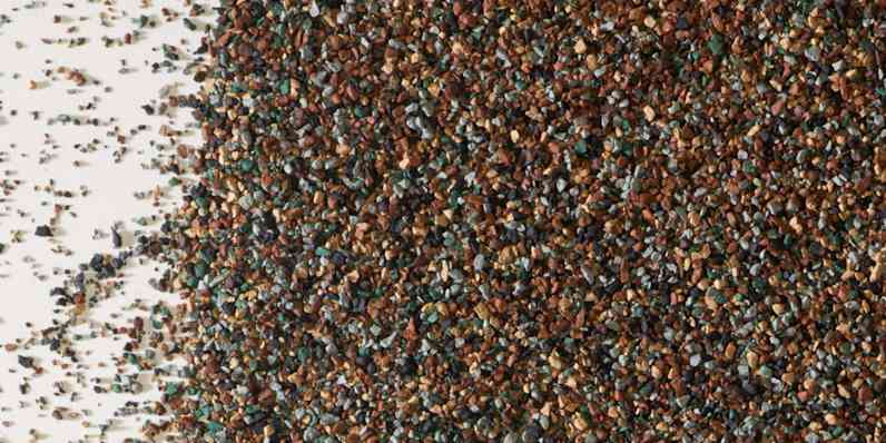 Closeup photo of shingle granules in brown, gray, green, and tan colors