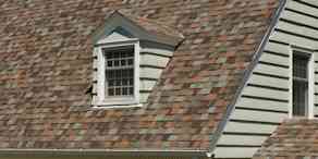 House with tan siding, two dormers with tan windows and Owens Corning Aged Copper shingles.