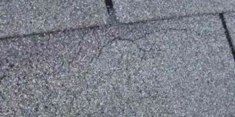 Asphalt roof shingle with signs of cracking