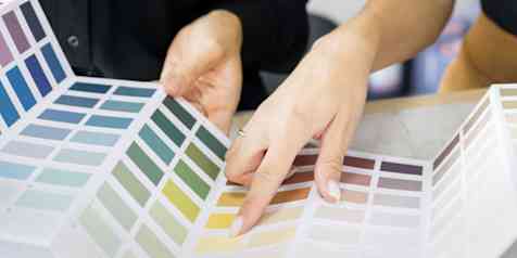 Photo of two people looking through a color swatch booklet