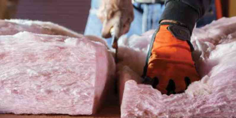 Man installing batt insulation in ceiling