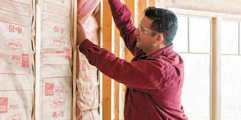Person installing wall insulation