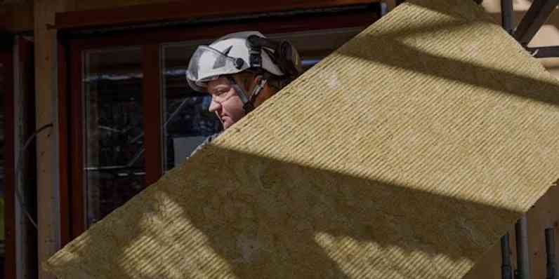 En man bär en stenullsskiva