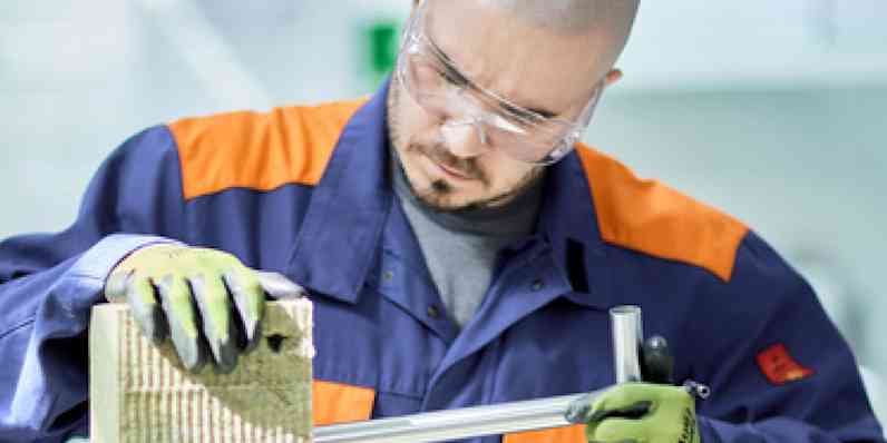 Blue-colored worker inspecting stonewool