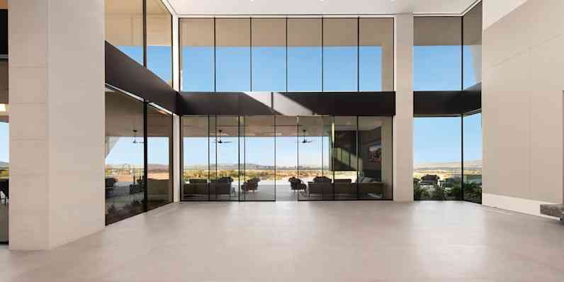 Interior view of a minimalistic, clean lined building with floor-to-ceiling windows.