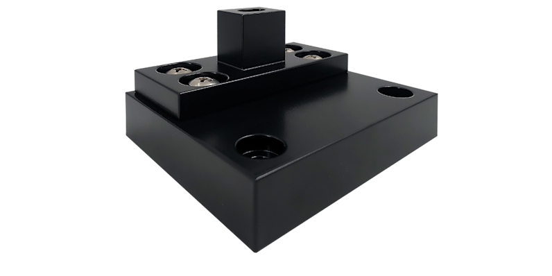 Black anodized aluminum pivot door hardware component with precision-machined base, integrated bearing system, and square spindle mount for high-performance architectural applications.”