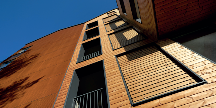 A building seen from beneath with the sky in the background.