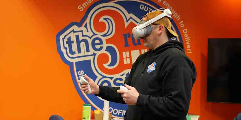 Man wearing virtual reality headset wearing a black hoodie.