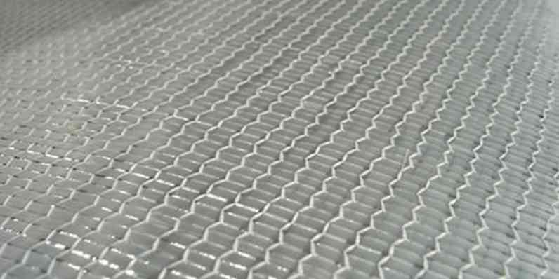 Close-up of a woven fiberglass fabric showing a tight, uniform grid pattern.