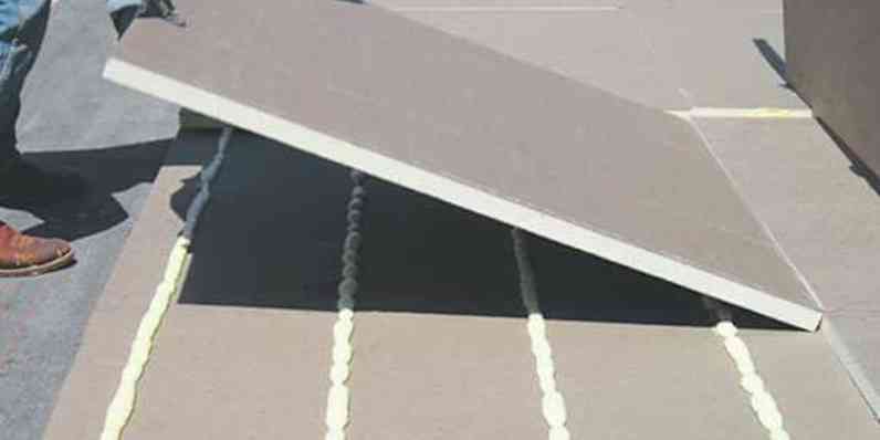 A woman installs gypsum wallboards with a power drill