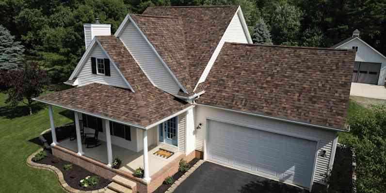 House with white siding and a Summer Harvest roof