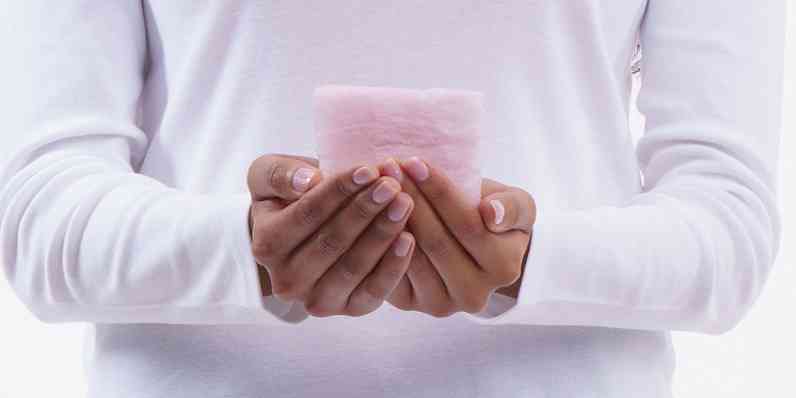 Person holding a small piece of PINK Next Gen® Fiberglas™ insulation in their hands