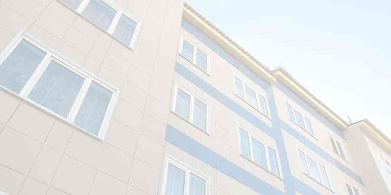 A building seen from beneath with the sky in the background.