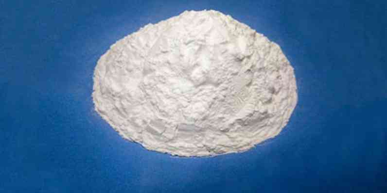 Pile of fine white powder displayed against a solid blue background.