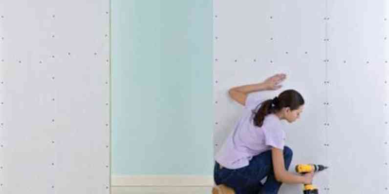 A worker installs insulated roof deck panels on the roof. 