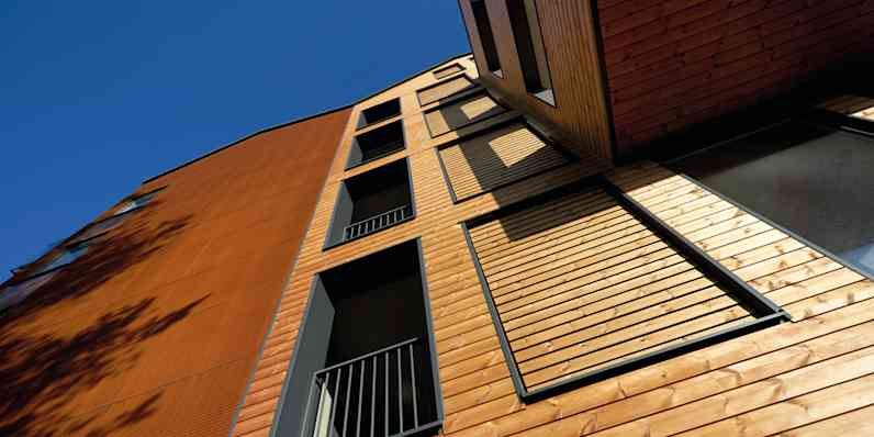 A building seen from beneath with the sky in the background.