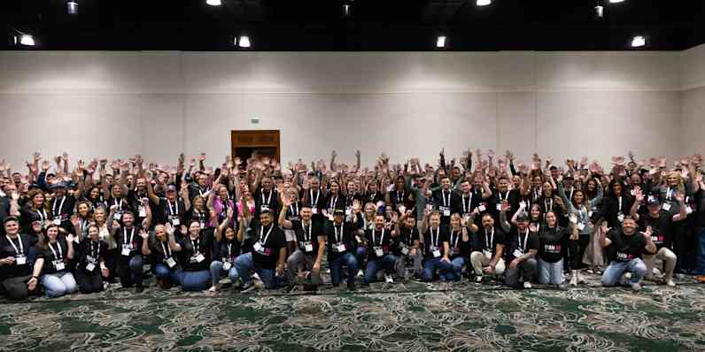 Photo of a very large group of people smiling and celebrating following a volunteer event