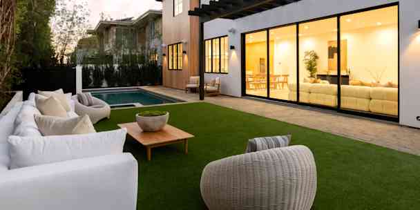 Clear huge sliding glass windows with in ground pool and outdoor furniture