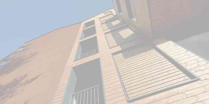 A building seen from beneath with the sky in the background.
