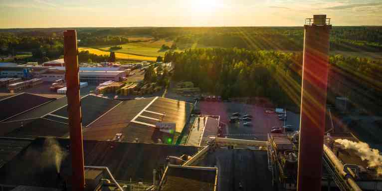 eine Paroc-Fabrik in Parainen mit grünen Wäldern im Hintergrund