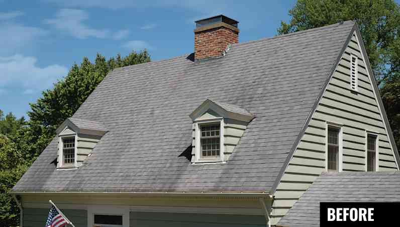 House with tan siding, two dormers with tan windows and ugly tan-grey roof with dark algae streaking.