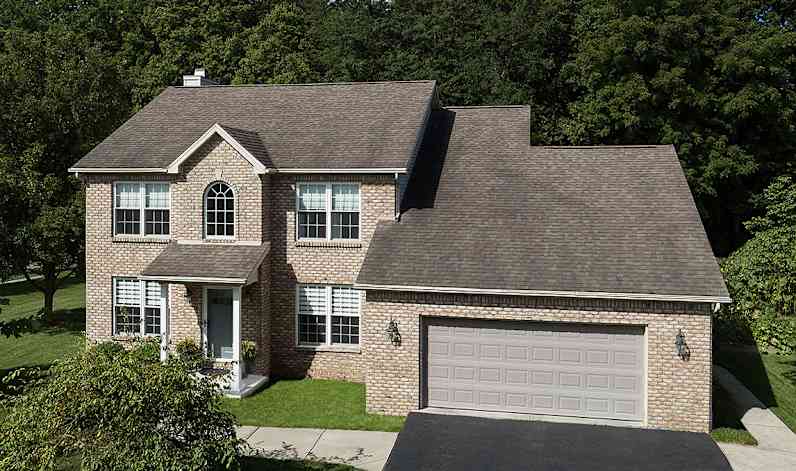 Una casa de dos pisos con techo de color marrón envejecido.