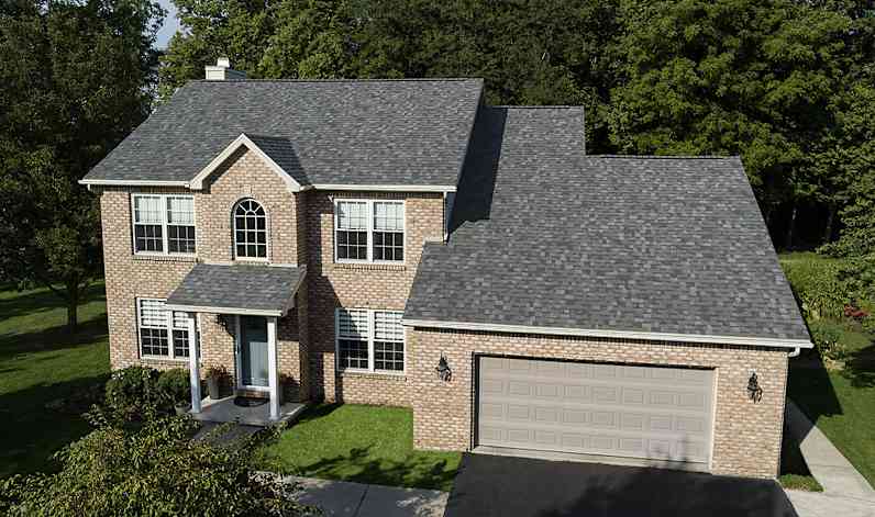 Una casa de dos pisos con techo nuevo de color Williamsburg Gray