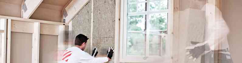En mand isolerer og bygger rum på loftet