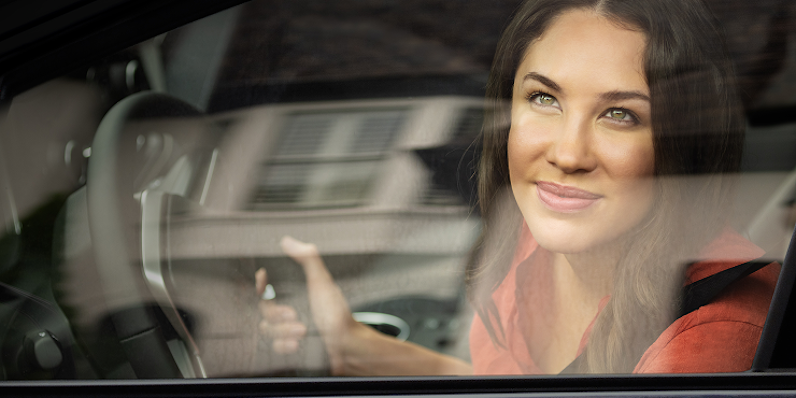 Woman gazing out her car window at a home's roof