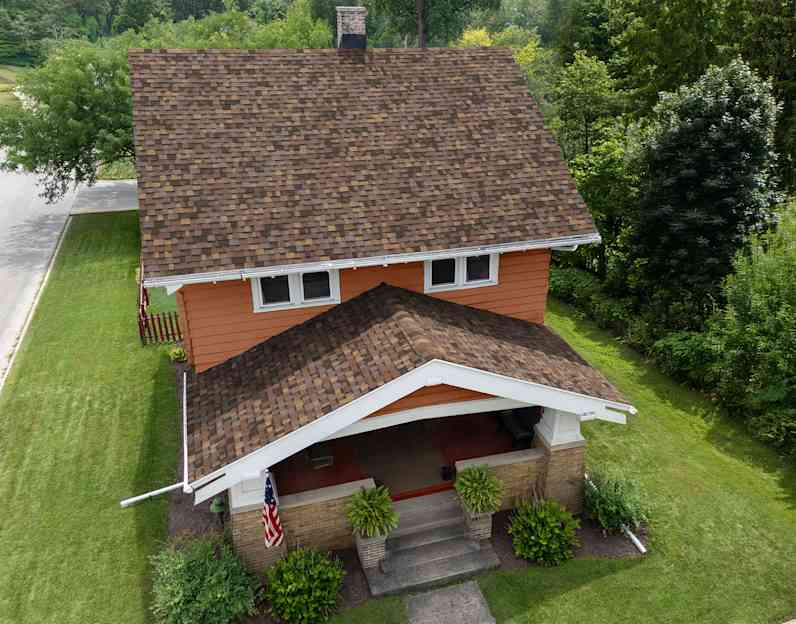 An orange sided two story house with new Summer Harvest roof