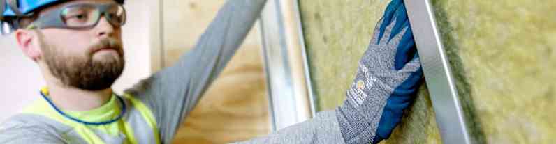 en mand iført beskyttelsestøj isolerer indersiden af ydervæggen