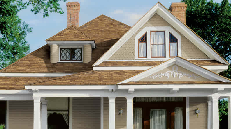 Photo of a tan house with brown Supreme® Metric Shingles on the roof