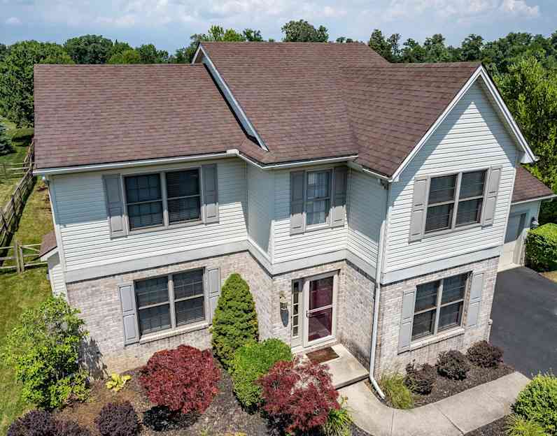 Una casa de dos pisos con techo de color marrón envejecido.