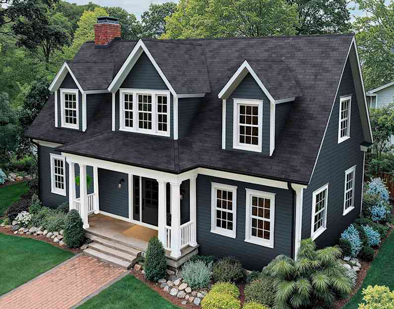 A deep blue two story house with older dark gray shingles