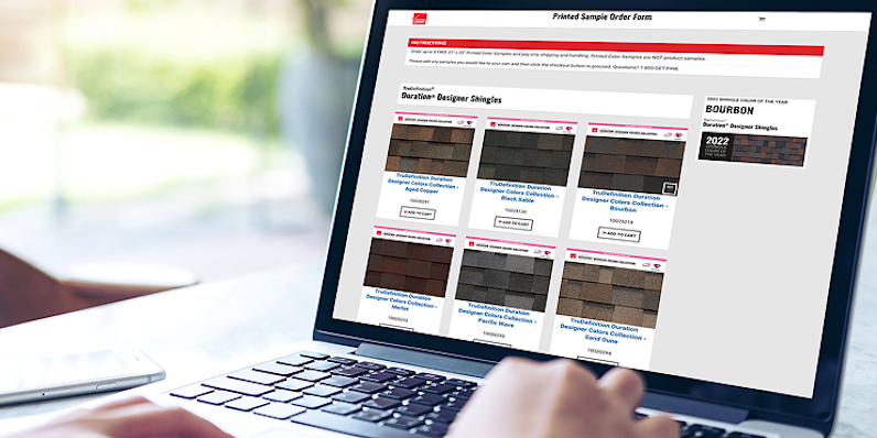 Persona que utiliza una computadora portátil para explorar los carteles impresos de tejas de Owens Corning