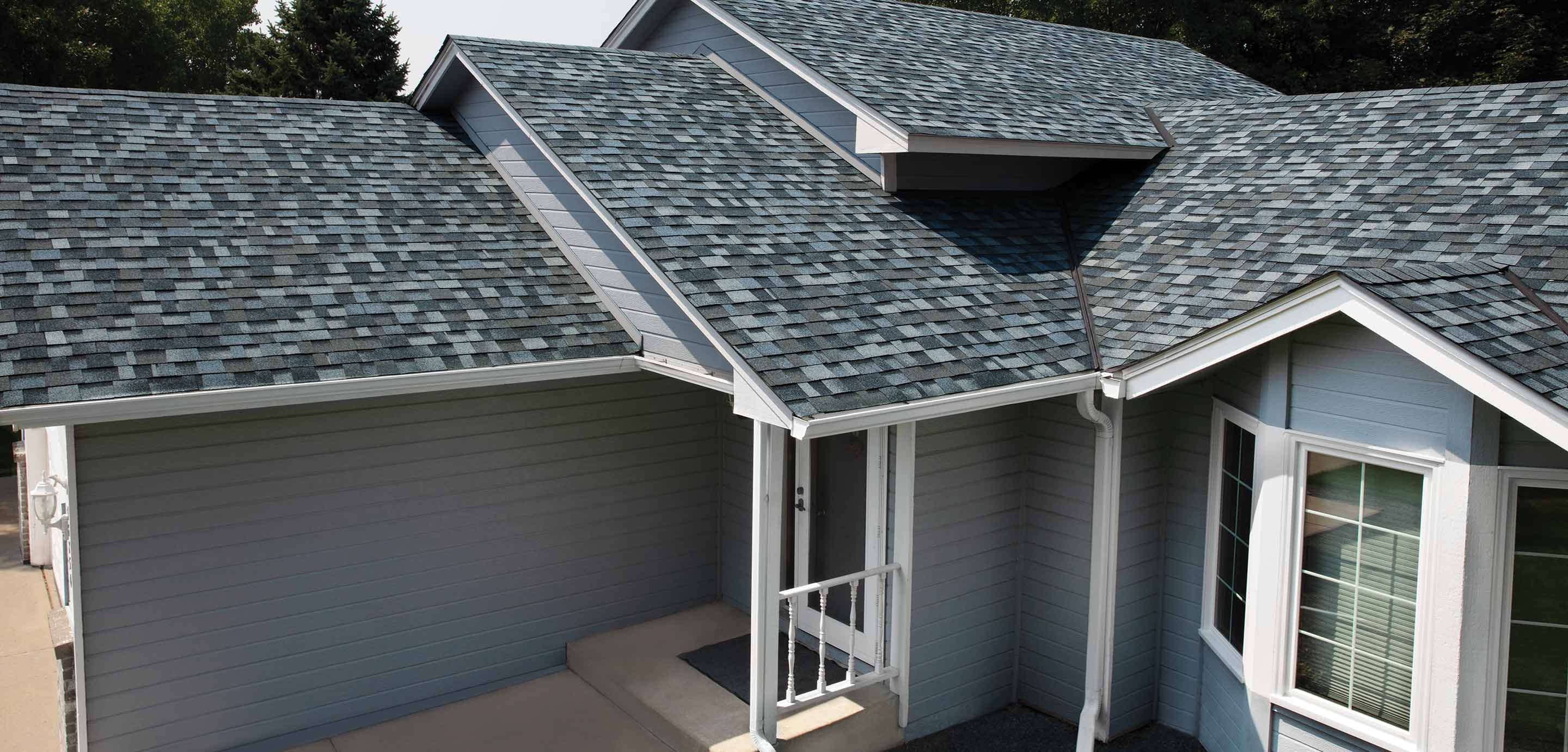 Pacific Wave Shingles on a gray house with white trim.