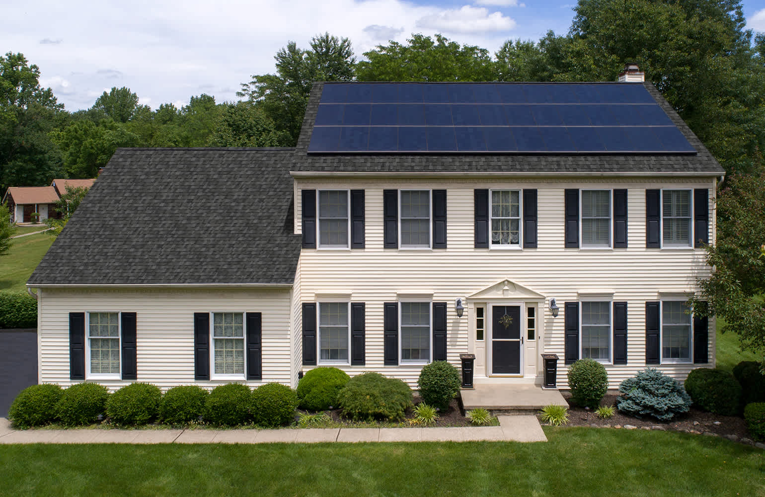Two-story home with solar panels installed on its asphalt shingle roof