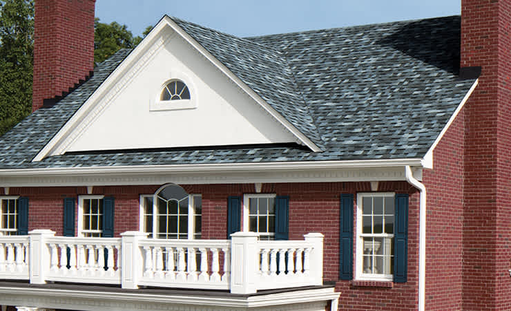 Photo of a red brick house with TruDefinition® Duration® Shingles Designer Shingles in Pacific Wave